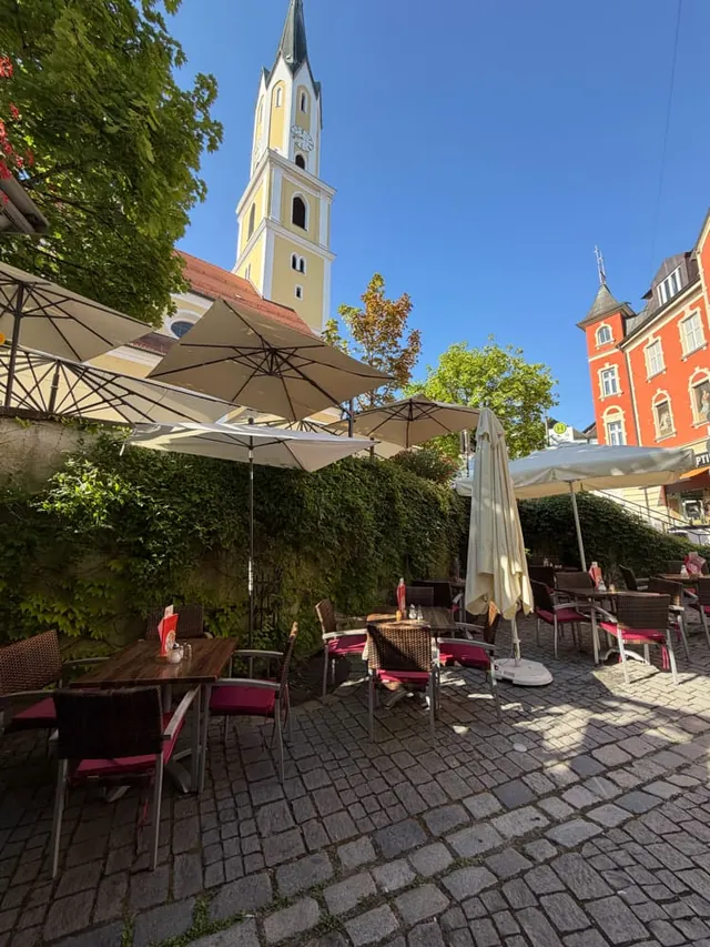 Our terrace with parasols on the cobblestones, with the tower of St. John's Church behind