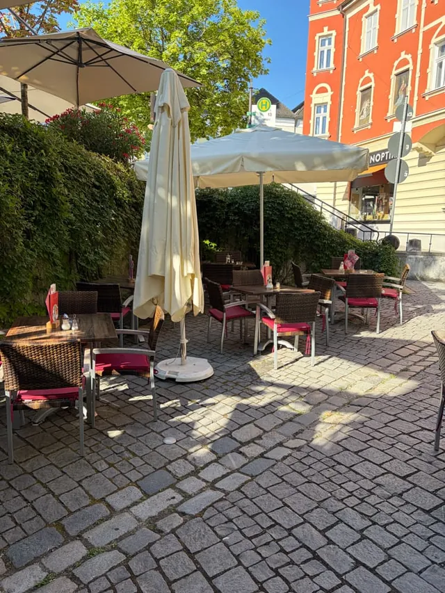 Tables under parasols on our terrace, with the colourful houses of Kirchplatz in the background