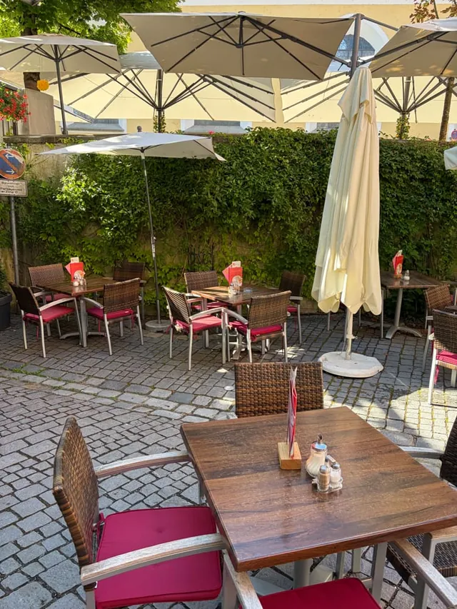 A laid table on the terrace in the shade of the parasols